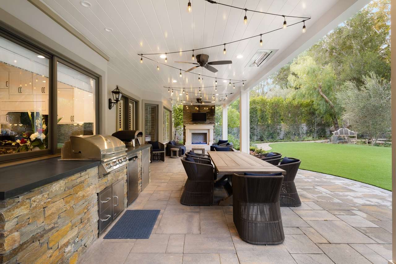 Outdoor kitchen with dining area and string lights